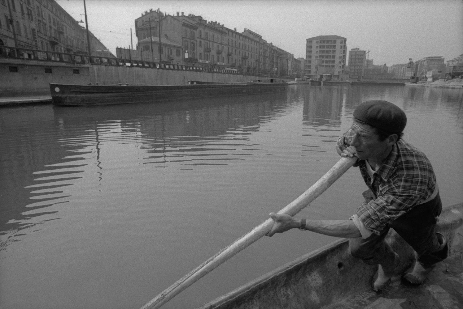 Toni Nicolini, Uomo trasporta della ghiaia sul barcùn, la tradizionale chiatta milanese, nella Darsena di Milano, Milano, 1970