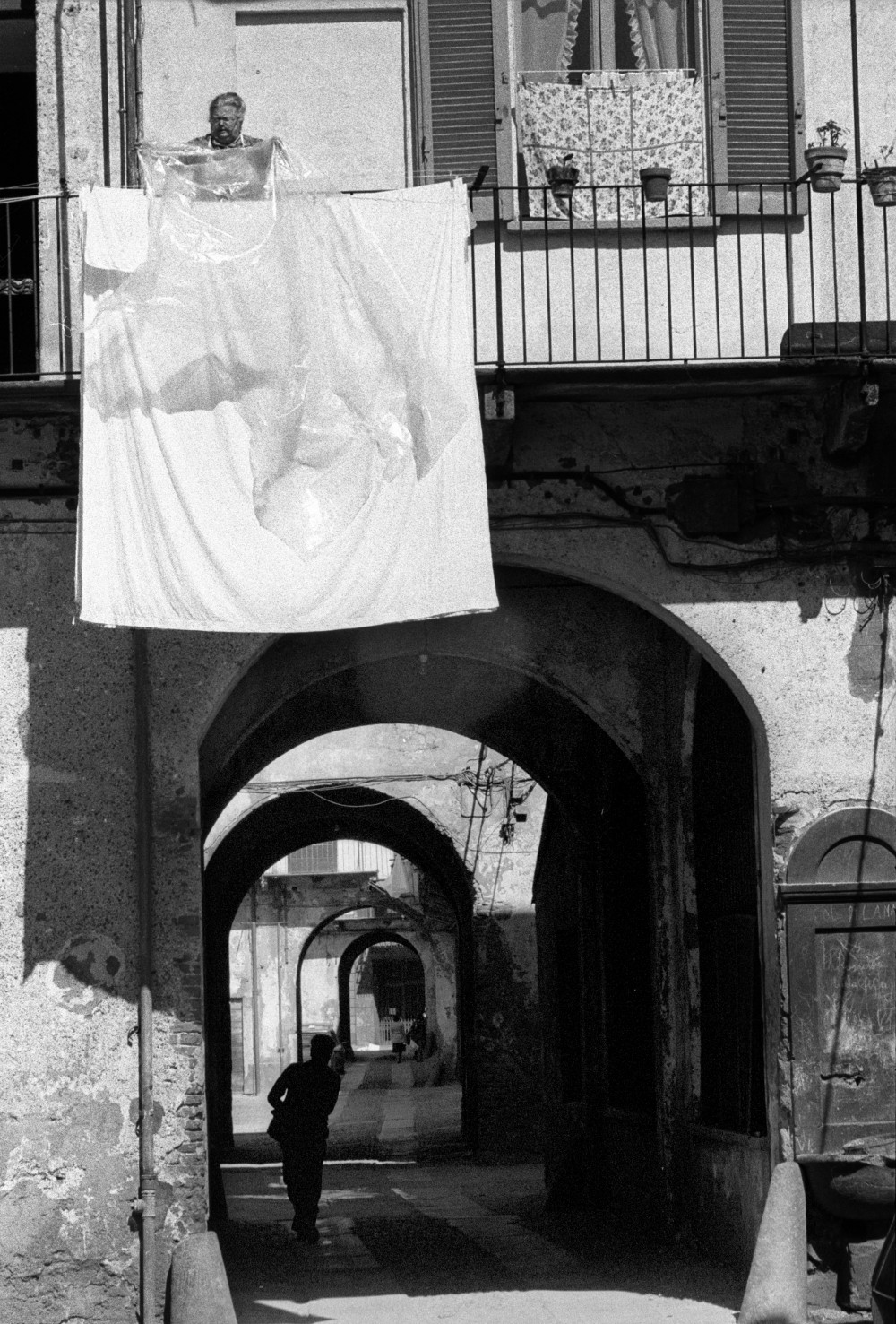 Toni Nicolini. Cortili di via Col di Lana 10. Donna stende il bucato Milano, 1978